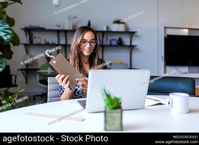 Creative businesswoman showing fabric swatch while video calling through laptop