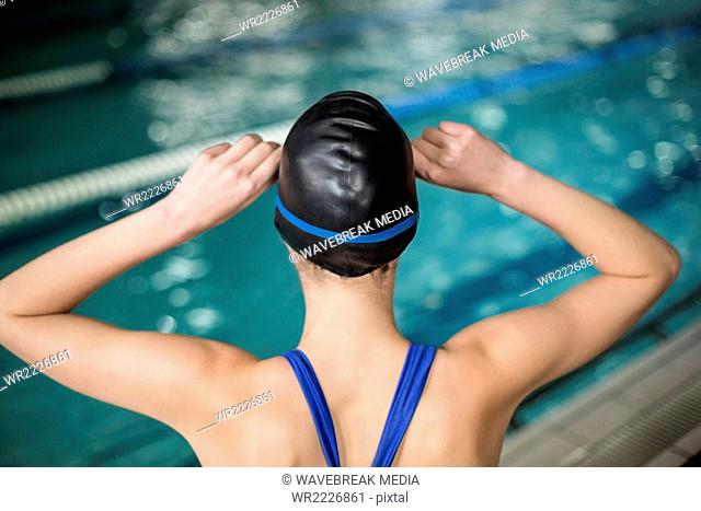 Rear view of fit woman with cap and goggles