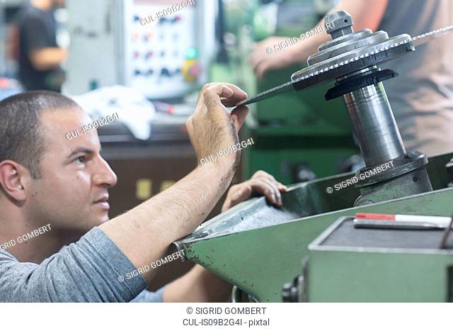 Man checking rotary blade on grinding machine