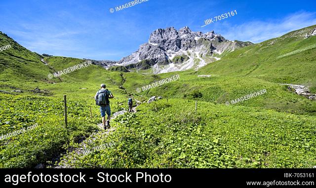 Two hikers on a hiking trail, hiking trail to the Kemptner Hut, in the background rocky mountain peaks of the Kratzer, Heilbronner Weg, Oberstdorf, Allgäu