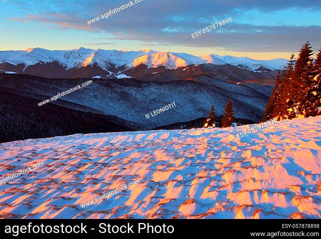 winter landscape with mountains under evening sky with clouds