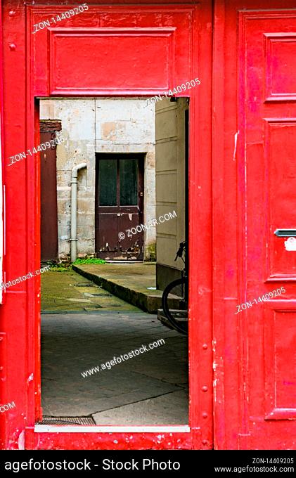Rouen, Seine-Maritime / France - 12 August 2019: bright red door opening into an inner courtyard with another door