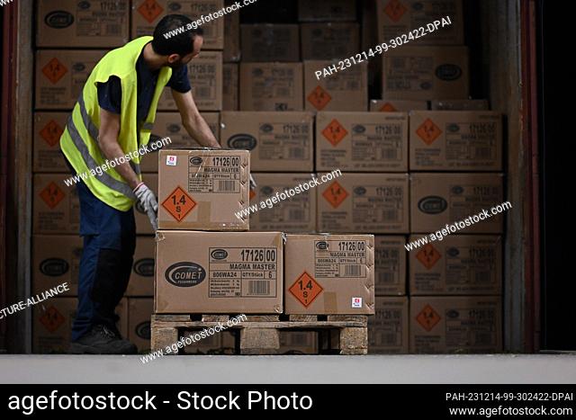 PRODUCTION - 14 December 2023, Bremen, Bremerhaven: Employees of the pyrotechnics company, Comet Feuerwerk GmbH, empty an overseas container filled to the...
