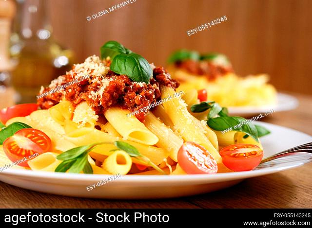 Rigatoni pasta with a tomato beef sauce on the oak table