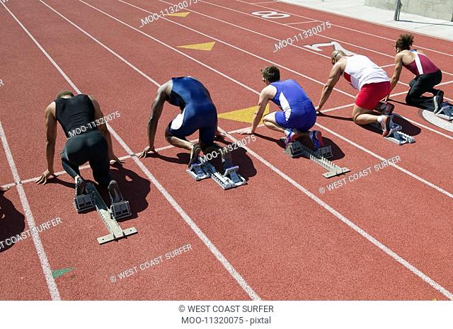 Male sprinters in starting blocks