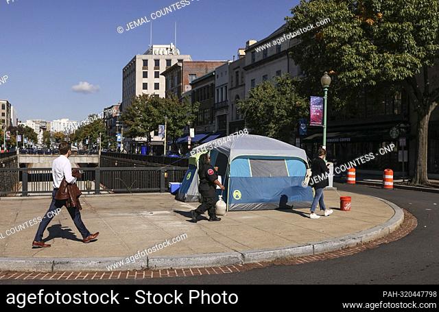 D.C. residents walk past one of two tents housing the homeless in the Dupont Circle section of Washington D.C. on Friday, October 14 2022 in Washington D
