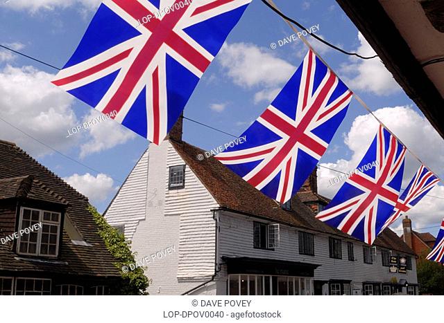 England, Kent, Brenchley, Bunting hanging underneath the overhang of a tudor house in celebration of the Tour de France passing through the village