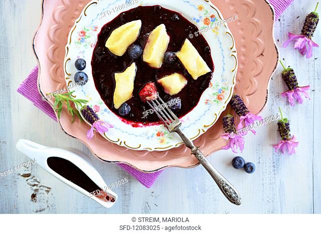 Polish vegan quark dumplings with blueberry sauce, fresh blueberries and lavender flowers