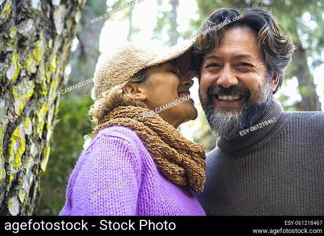 Man and woman adult couple smile and stay closer in the park. Outdoor leisure activity people together with love and complicity
