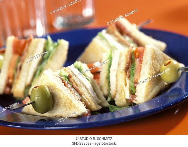 Club sandwiches on cocktail sticks with olives