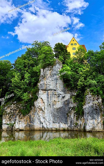 yellow house on a rock above the danube