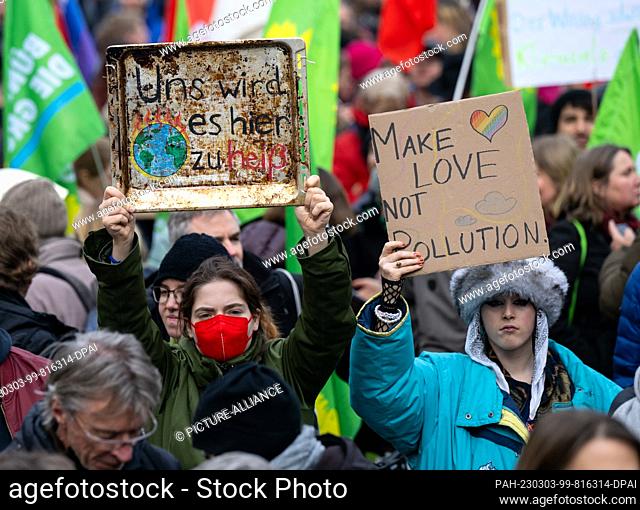 03 March 2023, Bavaria, Munich: Numerous people take part in a demonstration for the global climate strike, holding a black plate with the inscription ""It's...