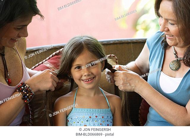 Mother and grandmother braiding girlÕs hair