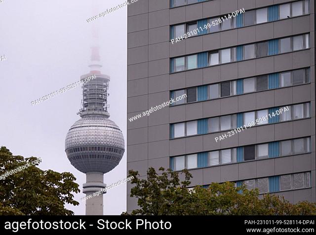 PRODUCTION - 09 October 2023, Berlin: The Berlin TV tower rises into the sky against the backdrop of a residential building in the Mitte district