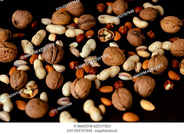 Nuts. Pistachio, walnut, hazelnut and peanut. Mixed nuts on black background