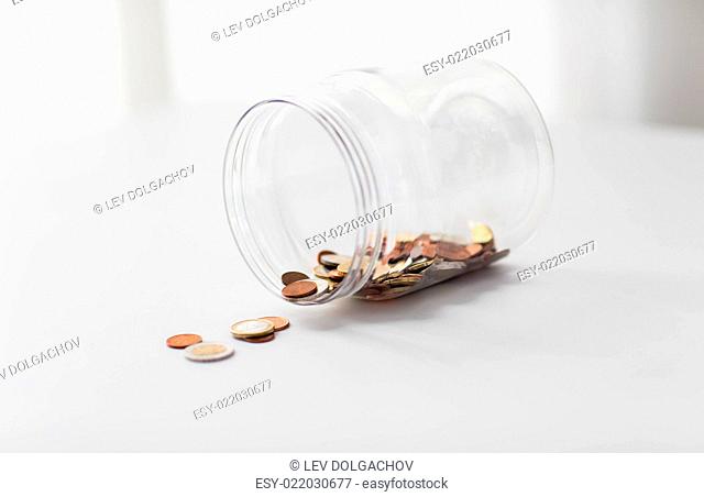 business, finance, investment, money saving and budget concept - close up of euro coins in glass jar on table