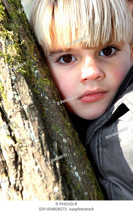 Young boy hugging a tree