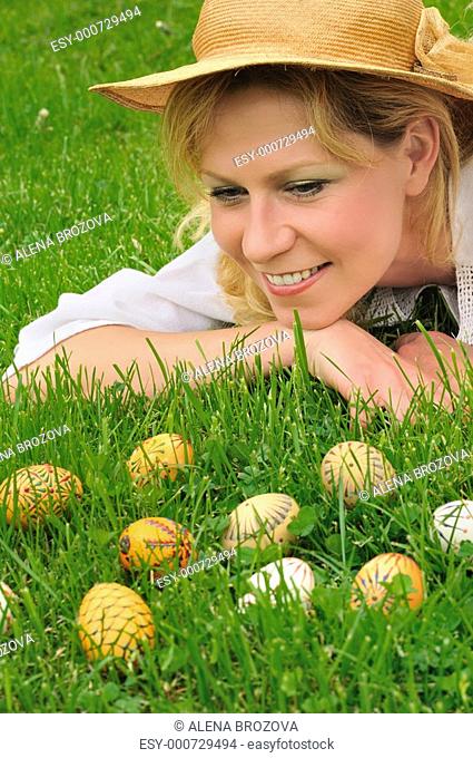 Young woman and easter eggs on grass - Easter time