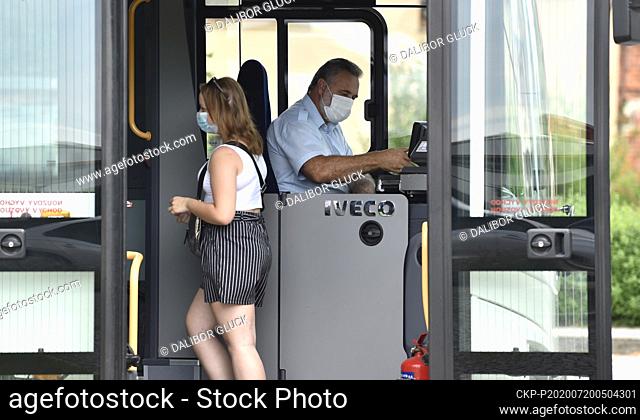 Passenger, left, and driver wear a face masks to protect against the spread of the coronavirus in a bus in Vlcnov near Uherske Hradiste, south Moravia