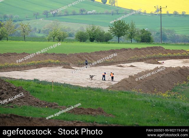 29 April 2020, Saxony-Anhalt, Rödigen: Excavation workers examine the remains of a so-called earthwork from the Stone Age at the construction site for a bypass...