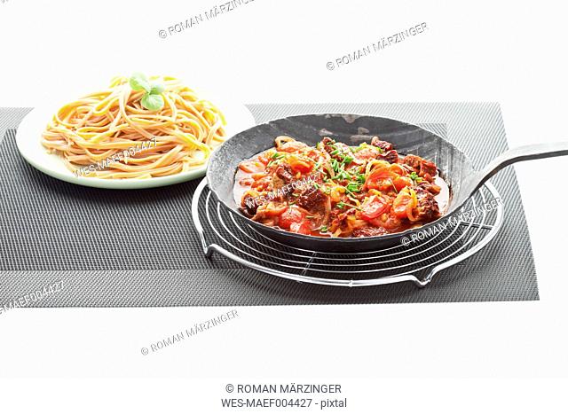 Linguini peperoncino rosso with pasta sauce on place mat