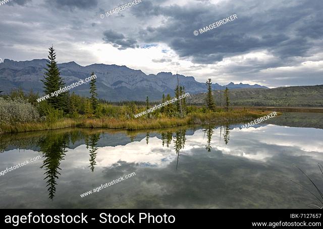 Hilly landscape, trees and mountains reflected in a lake, in autumn, Talbot Lake, Jasper National Park, British Columbia, Canada, North America