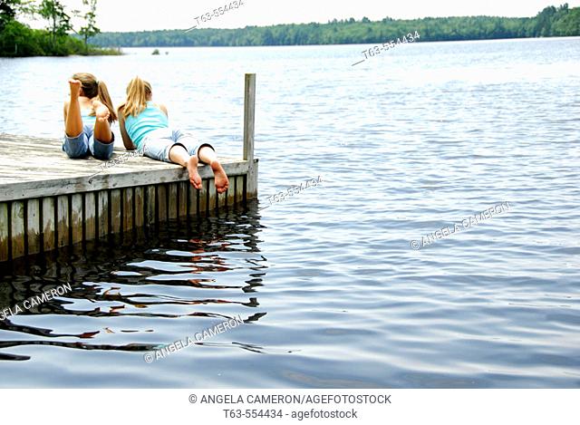 girl 13 with girl 18 together on dock looking out at lake