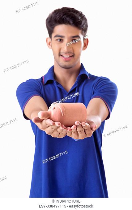 young college student holding a small piggy bank
