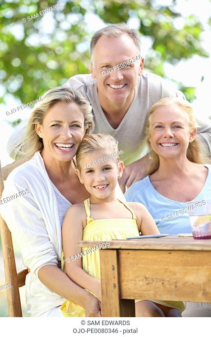 Portrait of smiling multi-generation family at table outdoors