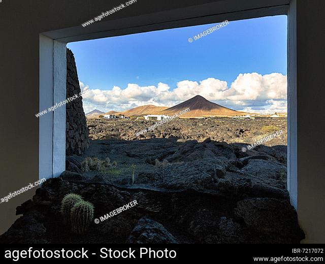 Window with black lava tongue, view of lava field and volcanic cone, former residence of the artist, Fundación César Manrique, Tahiche, Teguise, Lanzarote