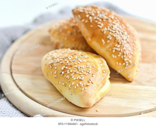 Dough stuffed with ham, cheese and pickles and sprinkled with sesame seeds