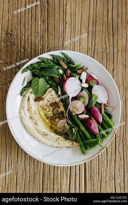 Hummus bowl with asparagus and radishes