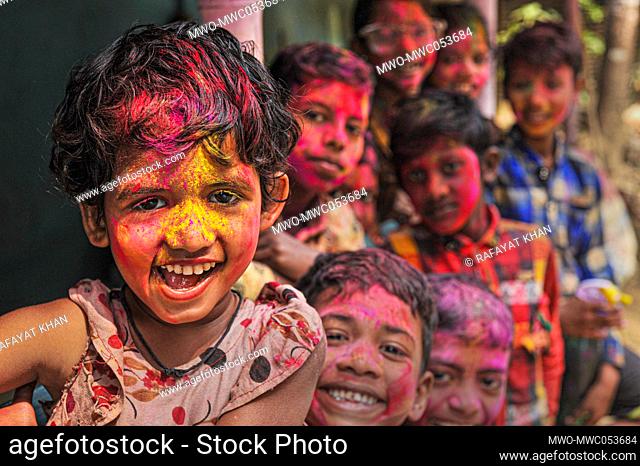 Children at a tea garden with painted faces in rainbow colours celebrating the annual Hindu festival of colors, known as Holi festival