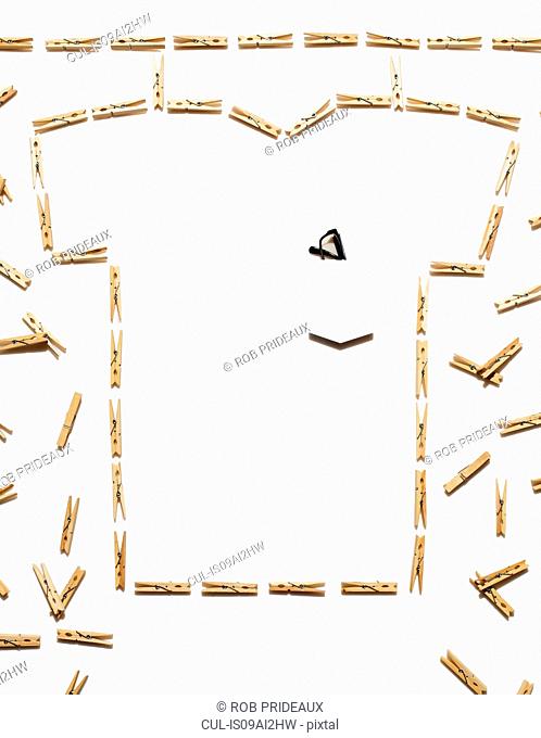 White tshirt outlined with clothespins on white background