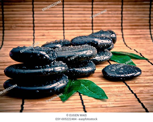 blak spa stones with leaf and water drops