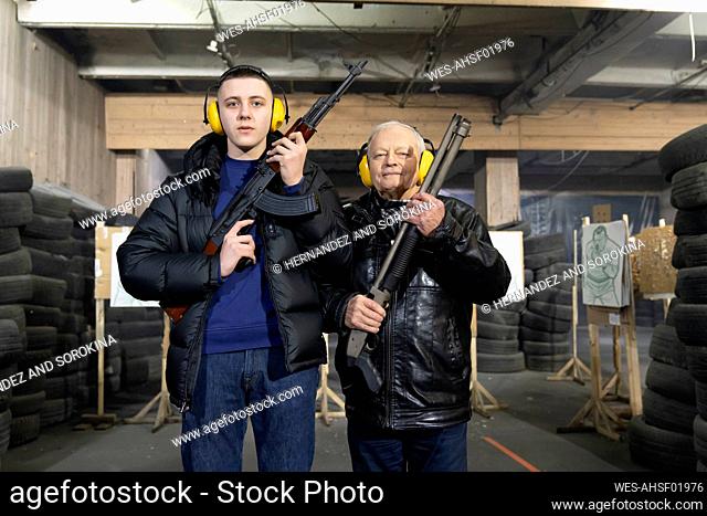 Portrait of grandchild and grandfather in shooting range
