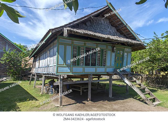 A village scene with a traditional house on stilts in the small village of Moyo Labuon on Moyo Island, off the coast of Sumbawa Island, Indonesia