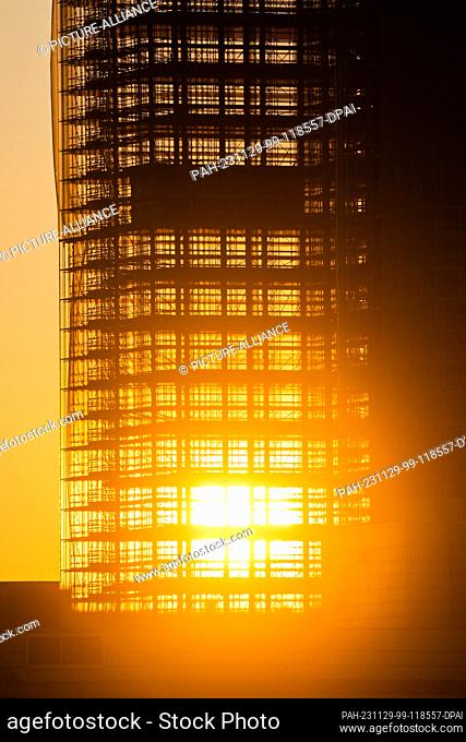 28 November 2023, Berlin: The sun sets behind the skeleton of the Steglitzer Kreisel skyscraper. Photo: Christoph Soeder/dpa. - Berlin/Berlin/Germany