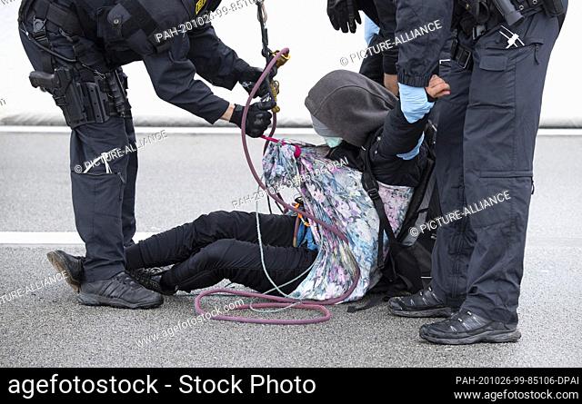 26 October 2020, Hessen, Zeppelinheim: An activist is arrested by police on highway 5. At the same time, several groups of environmentalists had rappelled down...