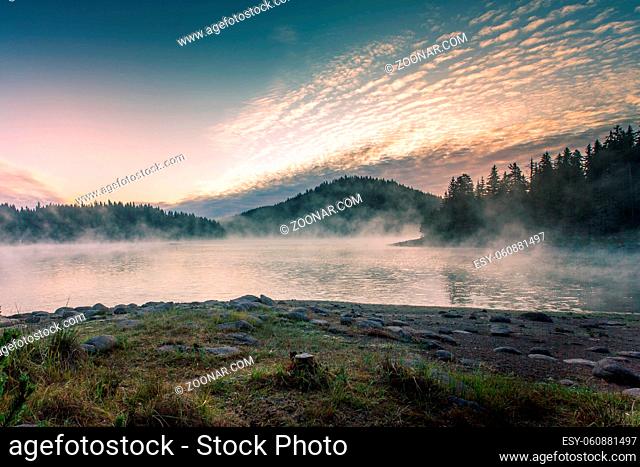 Morning misty fog at the lake, mountains pine tree forest landscape, Shiroka polyana reservoir dam, Bulgaria