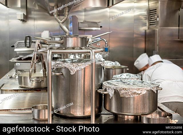 Chef preparing food in commercial stainless steel kitchen in restaurant