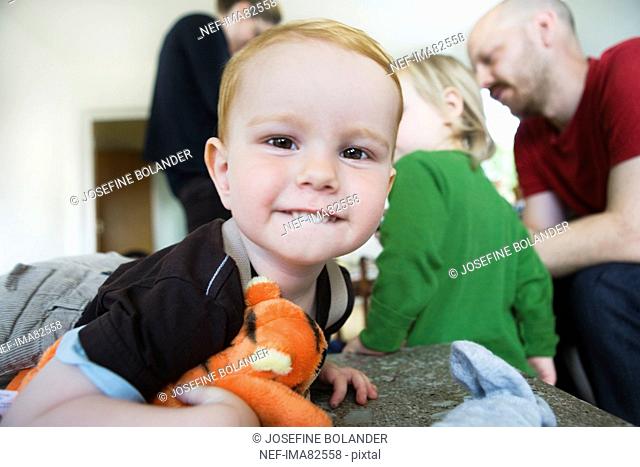 Boy biting lips, family in background