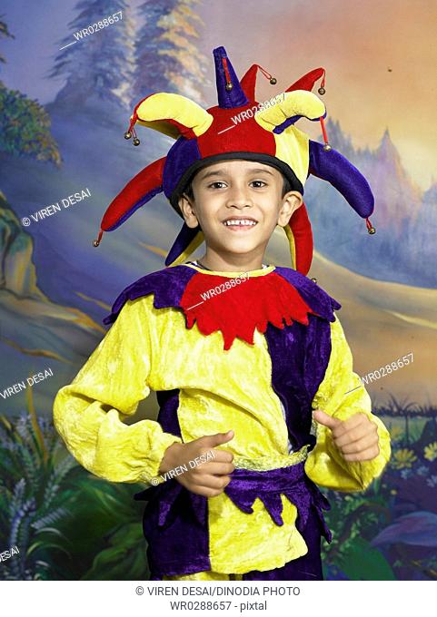 South Asian Indian boy dressed as joker performing fancy dress competition on stage in nursery school MR