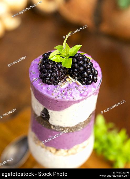 Blackberry smoothies with chia seeds in glass with fresh berries and mint on rustic wooden table