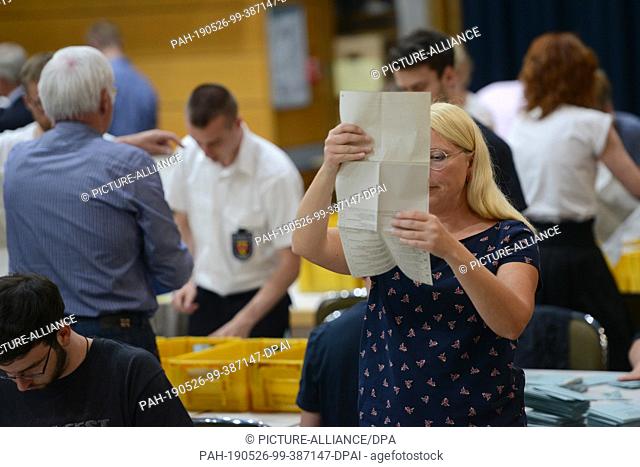 26 May 2019, Rhineland-Palatinate, Trier: An election assistant checks received postal voting documents for completeness and validity so that they can be...