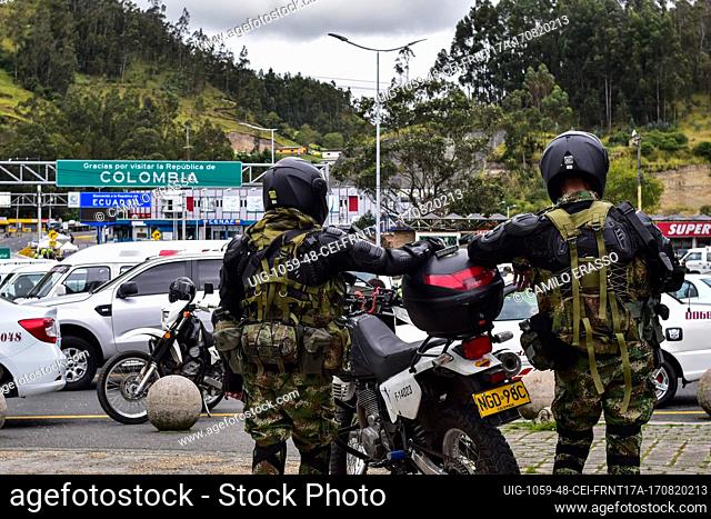 Colombia's army soldiers watch as drivers of public service vehicles hold protest on the Rumichaca International bridge that conects the countries of Colombia...