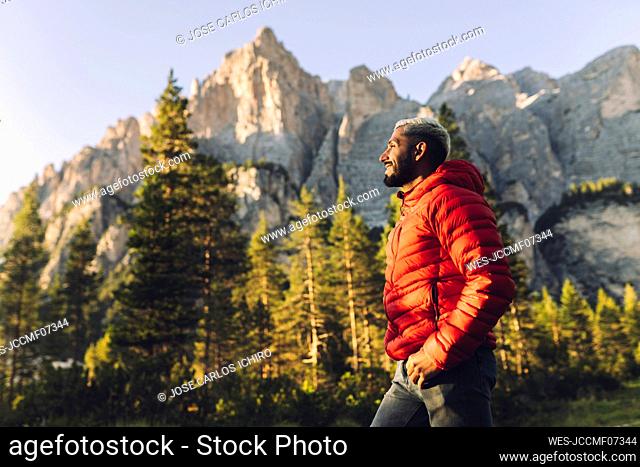 Smiling man standing in front of Dolomites, Italy