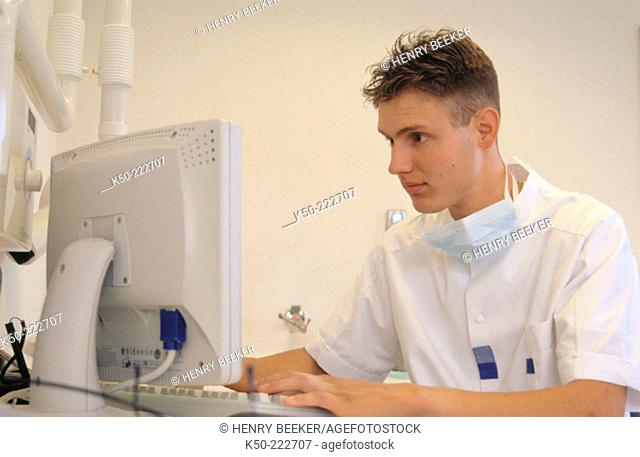 Dentist analysing data at his computer. Netherlands
