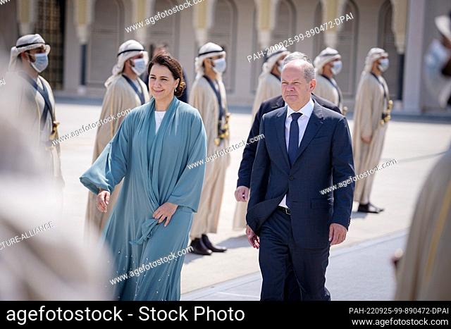 25 September 2022, United Arab Emirates, Abu Dhabi: German Chancellor Olaf Scholz (SPD) walks next to United Arab Emirates Minister of Climate Change and...