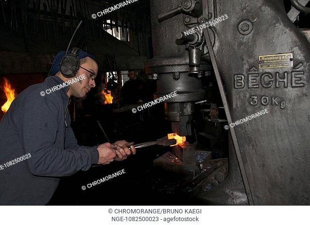 blacksmith working the steamhammer on redhot steel